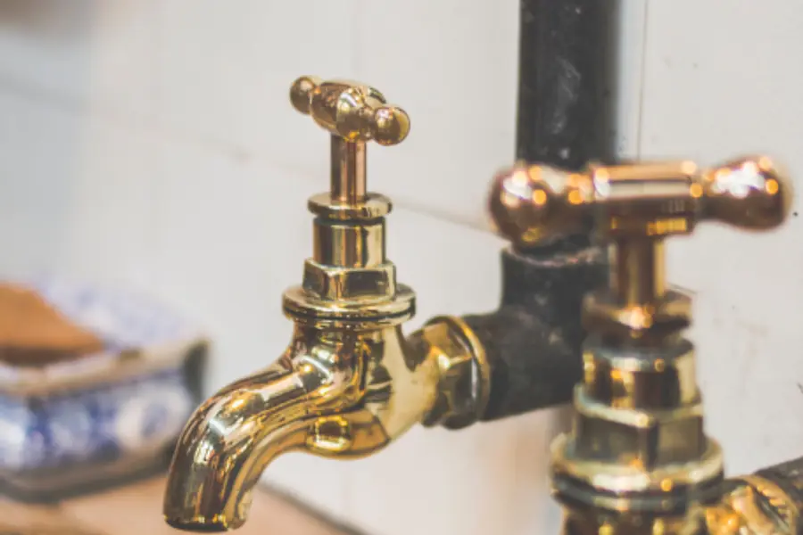 Llaves de agua de bronce sobre un muro